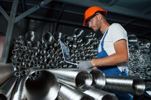 Made with special steel. Man in uniform works on the production. Industrial modern technology